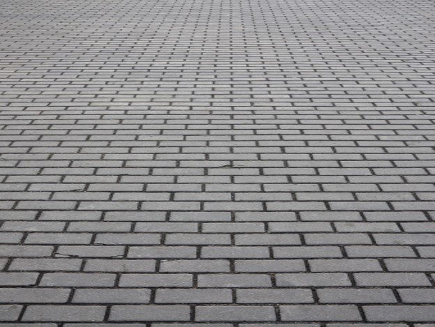 Gray brick paver driveway installed in a running bond pattern for residential property in Medina, OH