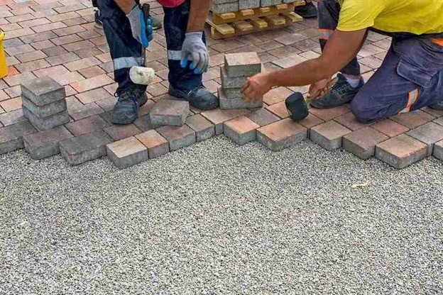 Concrete contractors installing paver driveway edge with gravel base preparation in Medina, OH