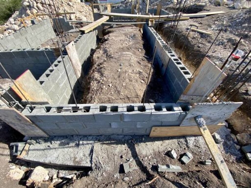 Concrete foundation installation with block walls and framing setup on construction site in Medina, OH
