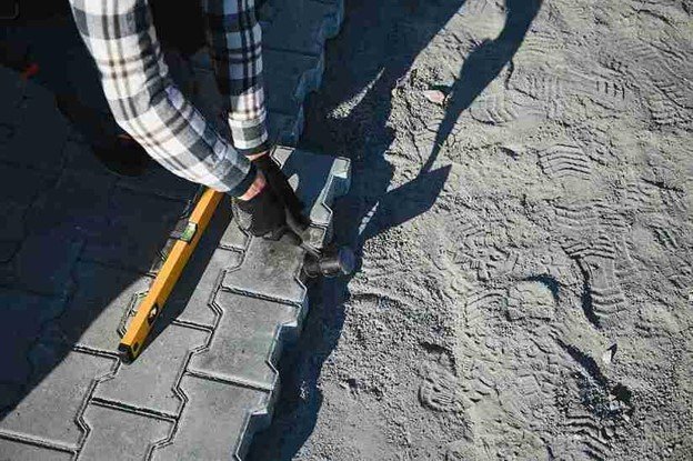 Stamped concrete installation with worker shaping and finishing textured surface in Medina, OH